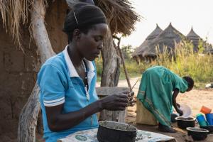 Asio Sarah, the aunt of Akwii's, cooking meal in her home in Kapelebyong 