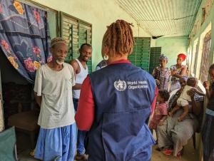 WHO staff, Ms. Aziza Amina Sahid, engages the community leader on the importance of COVID-19 vaccination