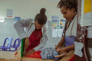 Mehonie the nurse updating the board with the newly admitted child's condition at the Stabilization Center (SC) to facilitate ongoing monitoring of the child's progress.