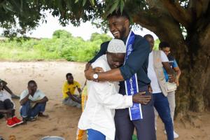 Mr. Supranational 2024, Dr. Fezile Mkhize, greets Pedro Mutaseque Paphelo, president of a leprosy selfcare group in Murrupula, Nampula, northern Mozambique, during a leprosy awareness campaign. Tiago Zenero/WHO Mozambique.