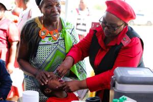 Health workers administering vaccines to children