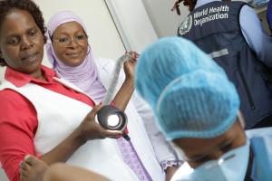 Dr Dille from WHO AFRO  looks on as the team conducts leep on a patient.