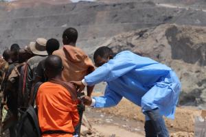 Dans l’ancienne mine à ciel ouvert de Tilwezembe, province du Lualaba (sud-est de RDC), des mineurs artisanaux reçoivent le vaccin contre la fièvre jaune, dans le cadre d’une campagne préventive. OMS/Vivian Nzabarinda