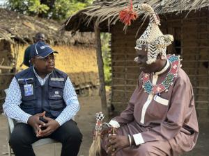Dr John Otshudiema, épidémiologiste et gestionnaire adjoint de l’incident Ebola pour l’OMS, échange avec le chef coutumier Bidiaka. Ce dernier lui explique comment les rites ancestraux ont contribué à accélérer le contrôle de la maladie à virus Ebola dans la zone de santé de Bulape. Crédit photo : OMS/René Ifono