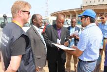 The Deputy Minister of Health (Administration), Hon. Mathew T.K. Flomo ( 2nd from right) signing the certificate of transfer of vehicles in the presence of the WHO Representative, Dr. Alex Gasasira (second from left).