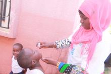 A vaccinator administering the polio vaccine to a child