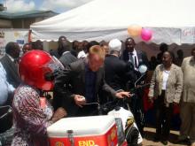 02 Dr Tatu Kamau Head Division of Vaccines and Immunization in red helmet receives one of the motorbikes from the Rotary representative during the WIW launch at Makadara grounds