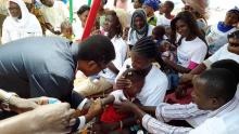 Dr. Charles Sagoe-Moses vaccinating a child shortly after the launching