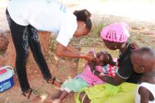 Trained vaccinator administering the polio vaccine to a child