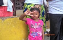 A young girl displaying the sign language of ‘l love you’, the others are looking at the interpreter on the other side