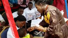  Permanent Secretary at the MoH administering deworming tablet to a child