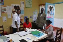 Amina, Isaiah and Jennifer go through case registers with Rita Gaceri, the nursing officer in charge at Kibugna health centre.