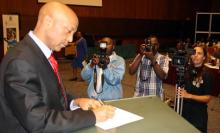 The WHO Country Representative Dr Wondimagegnehu Alemu Signing a pledge card for - A Promise Renewed