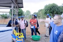 Un groupe d'une dizaine de personnes se forme à la circulation intérieure d'un Centre de traitement Ebola sous la supervision d'un encadrant. OMS/Eugene Kabambi