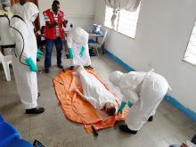 Avec un mannequin à l'appui, les apprenants, ici sous la supervision du responsable de la Croix-Rouge de la RDC, reçoivent les bons gestes pour un enterrement sécurisé d'une personne morte de la maladie à virus Ebola. OMS/Eugene Kabambi