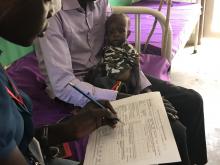 Medical doctor recording the daily management form to monitor the child’s progress. Photo: WHO.