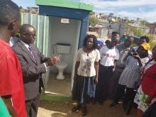 Councillor Martin David handing over one of three toilets he constructed as part of the HEV outbreak response