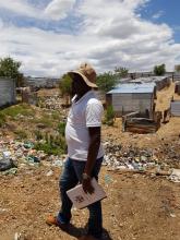 One of the Community Health Workers looking over a dumping site in Havana settlement