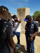WHO Representative Dr Charles Sagoe-Moses observing one of the communal water points in the Havana settlement