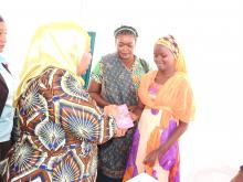 The Guest of Honor, Hon. Vice President handing over vaccination card to the vaccinated girl
