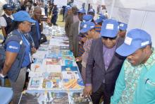 Les officiels de la RDC, Ministre d'Etat chargé du Travail et de la Prévoyance sociale, les autres membres du Gouvernement, le Représentant de l'OMS et  les autres partenaires conduits par le Ministre de la Santé, le Dr Oly Ilunga Kalenga pour la visite des stands - ici le stand de l'OMS au village Santé, à Kinshasa. OMS/Eugene Kabambi