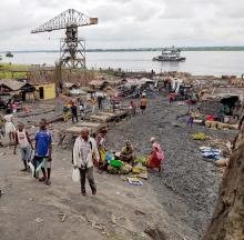 Une vue partielle du port privé Makila, près de Mbandaka, un des passages qui drainent les voyageurs, avec un petit marché de fortune aux abords du fleuve. OMS/Teresa Zakaria