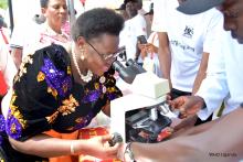 Minister of Health Dr Joyce Moriku views collected samples a microscope during at the TB day commemoration