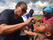 Dr Abi Kebra (WHO) administers vaccine to a child