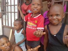 Les enfants de la zone de santé de Kasa-Vubu, à Kinshasa, sont heureux d'exhiber le bout du petit doigt contenant l'encre indélébile, après avoir reçu leur vaccin VOPb. OMS/Eugene Kabambi 