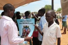 Students reading Tobacco control messages on a poster 