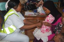 Nurse Onwunata administering a vaccine to a child at Dutse Alhaji PHC, Abuja.jpg