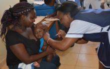 Baby Bayley receives her vaccine at Vihiga County Referral hospital as mom Yvonne Ingosi looks on