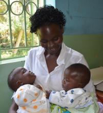 Twins Victoria and Victor held by mom Maureen, were among first beneficiaries  of the vaccine at Nyawara health centre in Siaya County