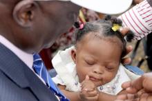 Le Représentant ad intérim de l'OMS, le Dr deo Nshimirimana portant un bébé avant l'administration du nouveau vaccin Rotasiil en marge de la cérémonie du lancement, Place de la Tour de l'Echangeur, Limeté, à Kinshasa. OMS/Eugene Kabambi