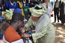 le Rep de l'OMS administrant la dose de vaccin à un enfant
