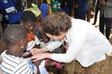 la Rep adjointe de l'UNICEF administrant la dose de vaccin à un enfant