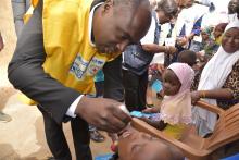 Le Medécin Chef du district sanitaire de  Cinkansé (Togo) administre des gouttes de vaccin à un enfant