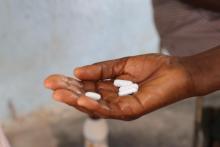              Mathias Nziramasarira’s hand receiving praziquantel, albendazole and mebendazole tablets