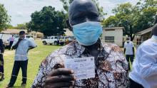 Mr Oguti shows his Yellow fever vaccine card