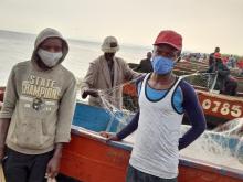 Fahad Barigira (in blue fabric face mask) flanked by his brother helped mobilize their colleagues for the brief interaction with the WHO team. 