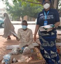WHO FCT Coordinator distributing IEC material to the kola nut vendor during COVID-19 survivors campaign in wuse market.jpg 