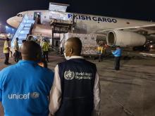 Deux logisticiens de l'OMS et l'UNICEF sur le tarmac de l'aéroport international de N'djili, lors de l'arrivée des doses de vaccins AstraZeneca contre le nouveau coronavirus, COVID-19 pour la RDC.