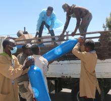 Workers unload 500 cylinders donated by WHO to EPHI as part of the donation of 3,000 cylinders to strengthen COVID-19 case management in Ethiopia