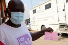 Cet homme montre fièrement sa carte de vaccination