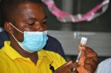 A vaccinator at JFK Medical centre preparing a vaccine for administration to a client