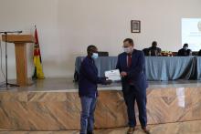 Representante da OMS Moçambique entrega certificado de participação a um membro da Assembleia provincial da província de Tete. 