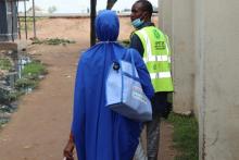 Personnel moving from house-to-house administering the malaria drug