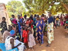 Women holding their babies wait for a measles vaccine