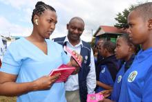 A nurse handing over vaccination cards 