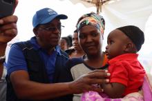WHO Staff interacting with Ms Rachael Molel, an inhabitant of the Babati community who brought her son to be vaccinated